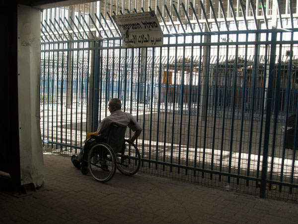 Man in wheelchair going through the humanitarian lane in Qalandiya Checkpoint, June 2011. Photo by Irus Braverman