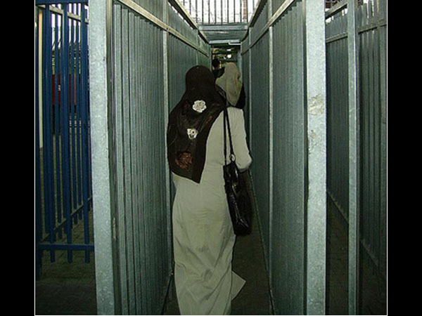 Women walking through metal turnstile, Bethlehem Crossing, 2009. Photo by Irus Braverman