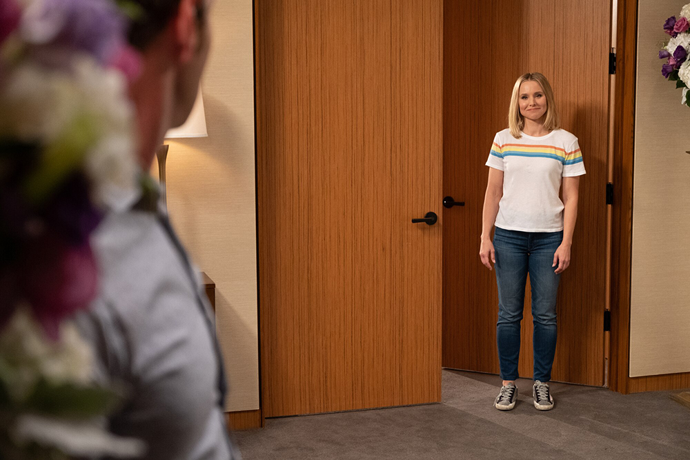 A women stands in an open doorway.