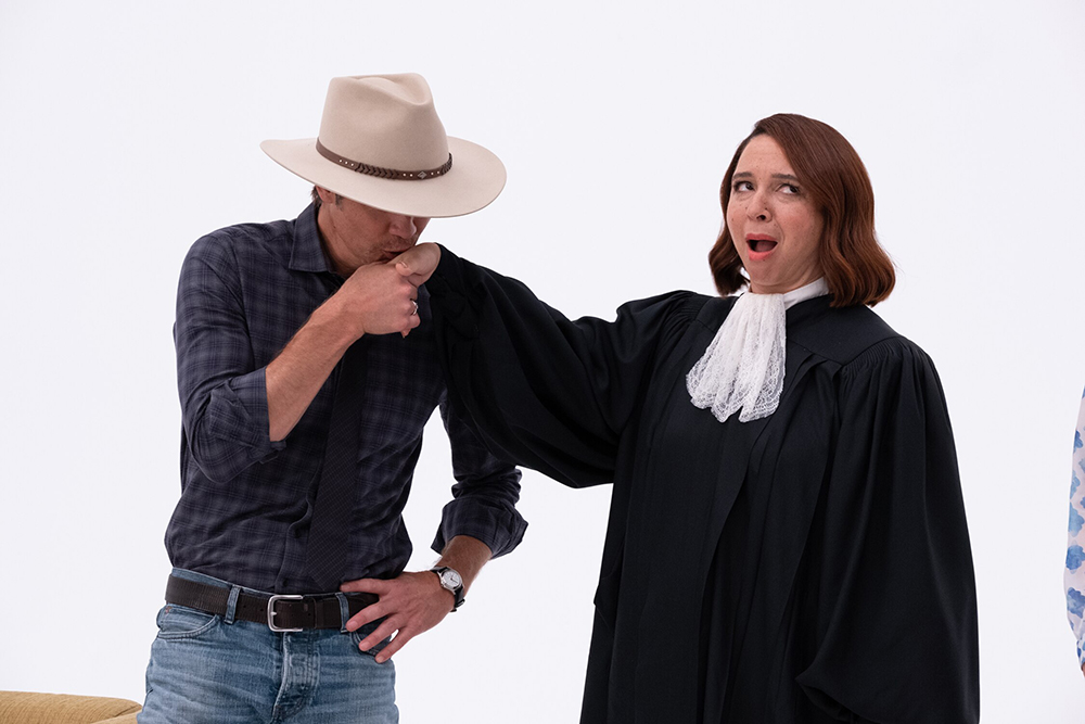 A cowboy kisses the hand of a judge.