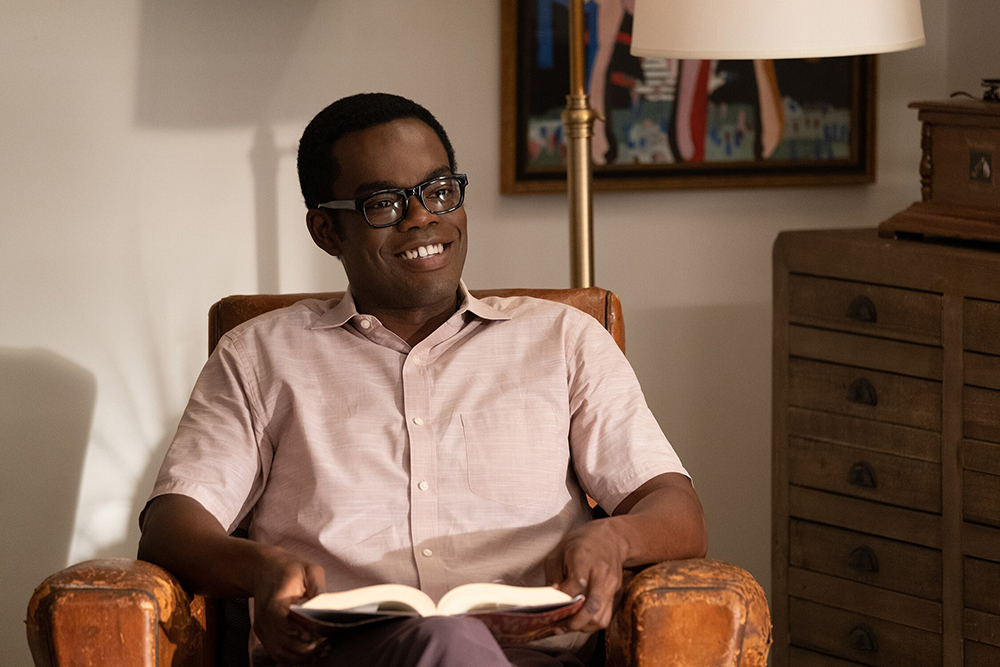 A man holding a book in a chair.