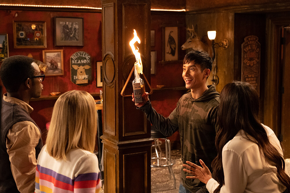 A man holds a flaming bottle.